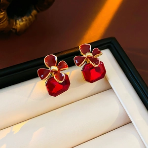 Close-up of vintage flower earrings with large red faceted rectangular gemstones in a box