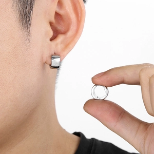 Close-up of 7mm silver titanium steel hoop earring worn on ear and held by fingers