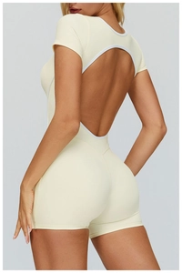 Detail of the open back cutout design with white trim on a cream fitness bodysuit