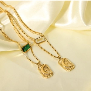 Detail of layered gold necklaces with sun and moon pendants and zircon crystals