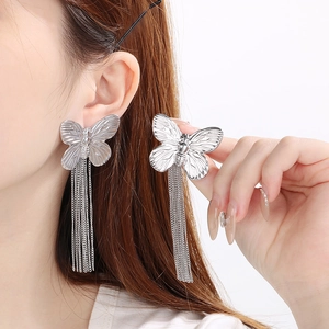 Detailed view of silver butterfly stud earrings with long tassel chains on model