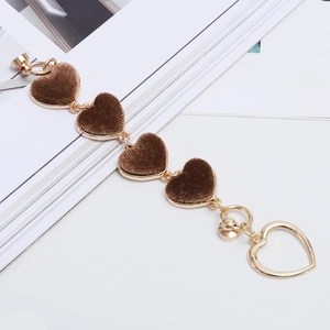 Detail of heart-shaped plush phone chain with brown velvet inlay and gold alloy finish