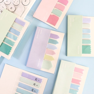 Detailed view of colorful sticky index tabs on a blue desk with office accessories