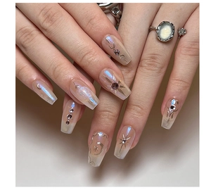 Detail of iridescent long coffin press-on nails with golden star moon and rhinestone accents