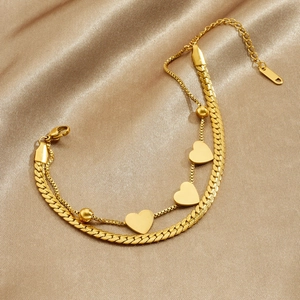 Double-layered gold-plated stainless steel heart bracelet on champagne silk background