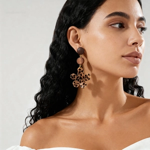 Gros plan de boucles d'oreilles fleur léopard avec accents en résine sur un mannequin rétro