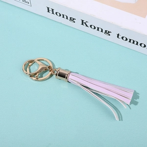 Pink and white PU tassel keychain with golden metal ring on a minimalist background