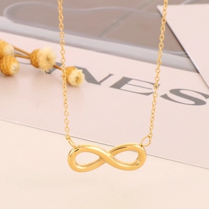 Macro view of golden infinity symbol pendant necklace on a 18k plated steel chain