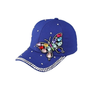 Royal blue baseball cap featuring a colorful rhinestone butterfly and studded brim