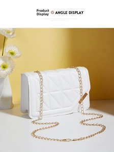 Detail view of white quilted faux leather bag with gold chain and metal side accents