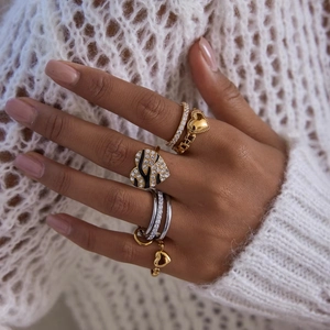 Close-up of stacked heart rings with rhinestones and black enamel on a hand
