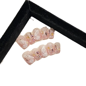 Pink gradient press-on nails with 3D white butterfly relief and rhinestone accents