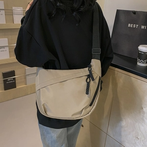 Minimalist beige nylon crescent crossbody bag with adjustable wide black shoulder strap