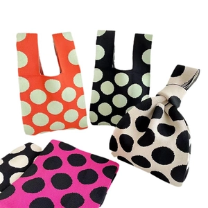 Polka dot knitted wrist tote bags in orange, black, cream and pink minimalist design