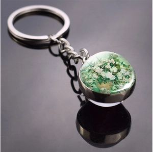 Detailed close-up of Van Gogh white roses oil painting in a glass ball metal keychain