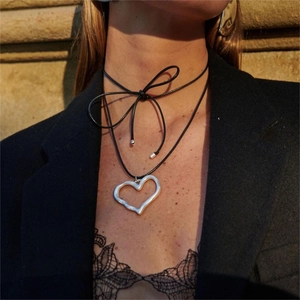Black cord choker with irregular silver heart pendant tied in a bow for women