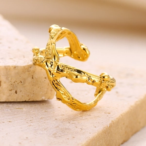 Macro view of gold heart ring with irregular organic texture on travertine stone