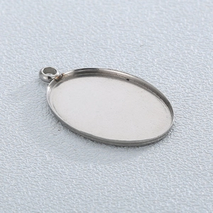 Macro view of a silver oval stainless steel pendant blank for DIY jewelry making