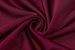 Macro shot of high-quality burgundy ribbed knit fabric with soft texture and elasticity