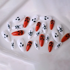 Halloween almond press-on nails with cute orange pumpkin and white ghost patterns