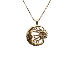 Détail du pendentif vintage doré avec motif soleil et lune et petites étoiles