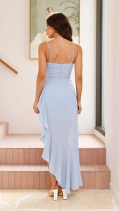 Détail d'une robe bleue dos nu avec ourlet à volants et fermeture éclair invisible