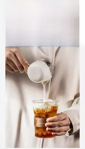 Detailed view of striped glass coffee cup with protective wooden heat insulation sleeve