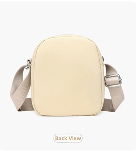 Rear view of cream nylon crossbody phone bag with adjustable wide fabric shoulder strap