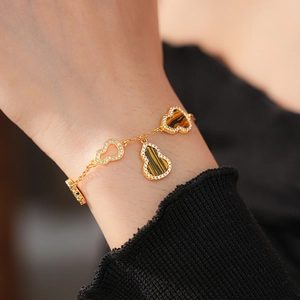 Macro shot of gold plated gourd bracelet with tiger eye stones and cubic zirconia on wrist