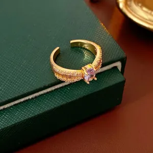 Verstellbarer Goldring mit ovalem lila Edelstein und Zirkon-Besatz auf grüner Box