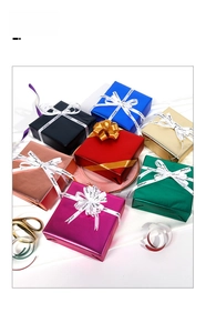 Detailed view of matte metallic gift wrapping paper rolls with silk ribbons and bows