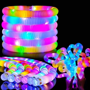 Detail showing glowing LED pop tubes being stretched and twisted in the dark