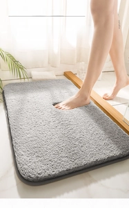 Close-up of plush grey bath mat showing thick absorbent fibers and soft texture
