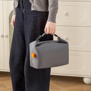 Waterproof grey insulated lunch bag with black handles and orange buckle detail