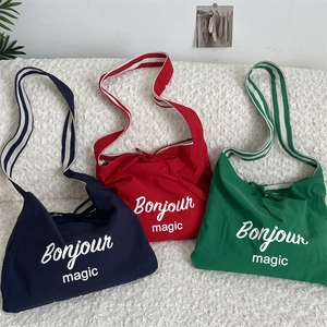 Détail des sacs cabas en toile rayée en bleu marine, rouge et vert éclatant