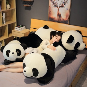 Détail de trois tailles de coussins panda en peluche dans une chambre douillette