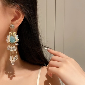 Close-up of vintage long fringe earrings with blue teardrop crystals and gold base