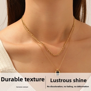 Close-up of double layer gold stainless steel necklace with rectangular black pendant on model