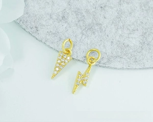 Macro detail of 18K gold plated star and moon charms with cubic zirconia inlay