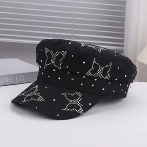 Close-up of black flat top cap with sparkling rhinestone butterfly and stud details