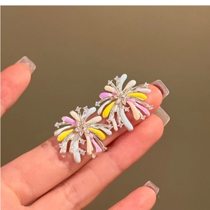 Close-up of colorful firework earrings with multicolored enamel and sparkling crystals