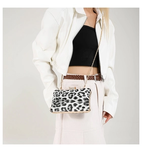 Close-up of leopard print evening clutch featuring gold metal frame and rhinestone clasp