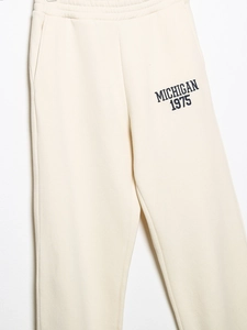 Détail du pantalon de jogging crème avec imprimé Michigan 1975 et taille élastique