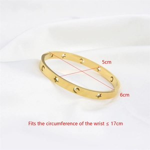 Hollow star and moon stainless steel gold bangle with sizing dimensions on white silk