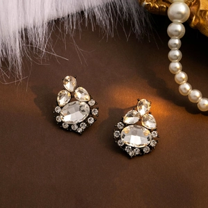 Detailed macro view of vintage bronze earrings with faceted crystal inlays on luxury fur