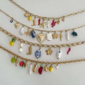 Détail de colliers en or 18K avec pendentifs colorés en émail, fruits et bottes rétro
