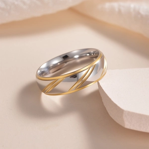 Elegant gold-accented stainless steel couple ring with diagonal grooves and crystal inlay
