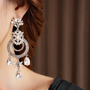 Détail de boucles d'oreilles vintage en argent avec cristaux brillants sur un modèle