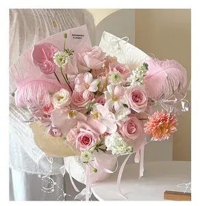 Exquisite pink rose and orchid bouquet featuring decorative white ostrich feathers and ribbon
