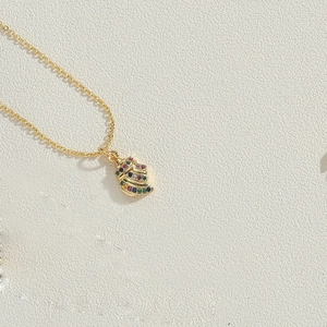 Detailed close-up of a 14K gold plated shell pendant necklace set with colorful zircons